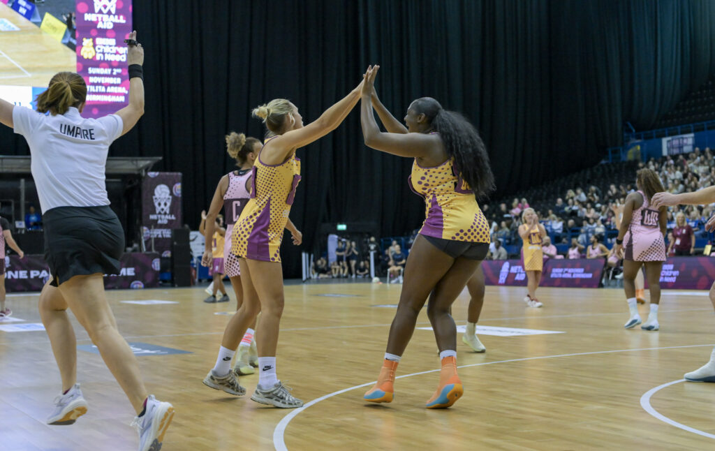 Two players high-five mid-game on the Utilita Arena court