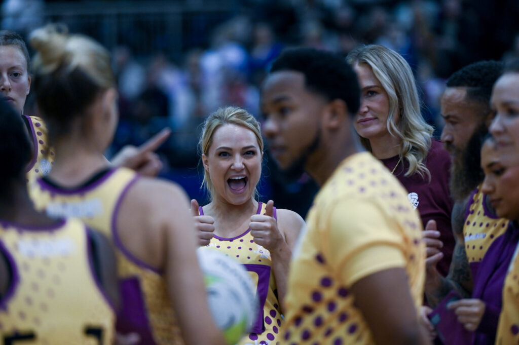 Players laugh together courtside, ball in hand